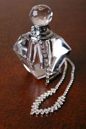 necklace draped on a perfume bottle
